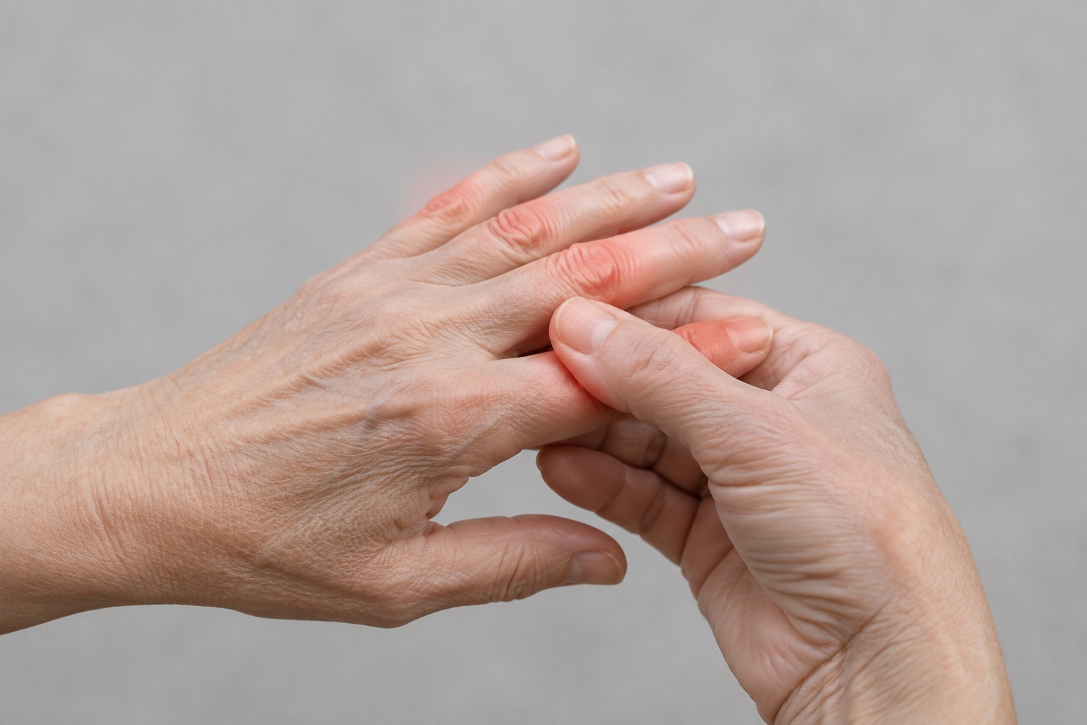 Older adult gently massaging sore finger joints